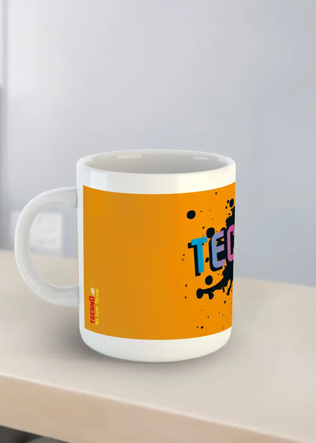 Eine Tasse von der Seite mit dem Text Techno und einem Splattereffekt im Hintergrund